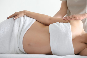 Poster - Young beautiful pregnant woman having massage in spa salon