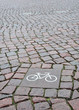 A sign of a bicycle path on a square stone 