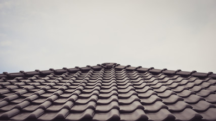 Dark brown ceramic tile roof . Toned image.