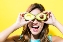 Happy Young Woman Holding Avocado Halves