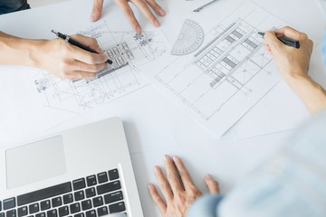 Wall Mural - Architects engineer discussing at the table with blueprint - Closeup on hands and project print, Team group on construciton site check documents and business workflow