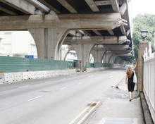 A Woman Walking Underneath An Overpass In Singapore