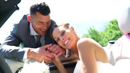 Wall Mural - Groom leading bride to get in convertible car