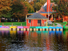 A Photo Of A Row Of Colorful Boats Floating In A Lagoon In Our Park With Reflections On The Water