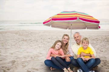 Sticker - Happy family at the beach under a colored parasol