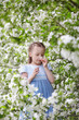 © hdesert - Cute little girl in blooming apple tree garden at spring