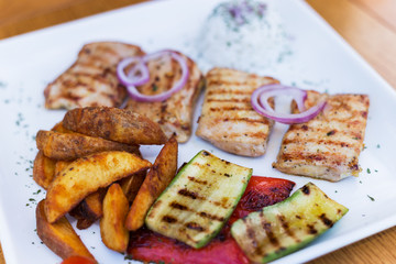 Wall Mural - Grilled chicken with grilled vegetables on white plate.