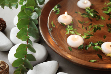 Wall Mural - Beautiful spa composition with green leaves and candles on water