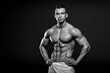 © sutulastock - Black and white photo of Muscular and fit young fitness model posing over black background.
