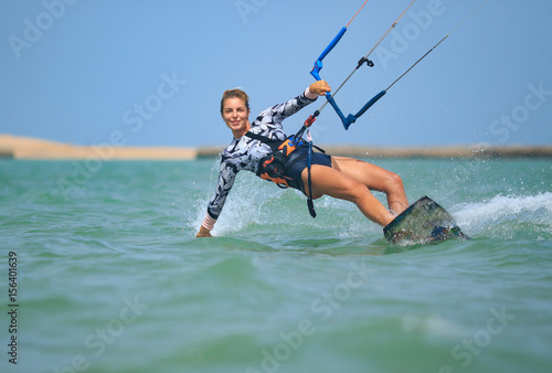 Zastosowanie fototapet  obraz-na-plotnie-kite-surfing-dziewczyna-w-seksownym-stroju-kapielowym-z-latawcem-na-niebie