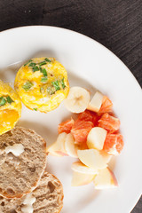  
Egg Muffin Cups with side of Oranges and Banana Fruit Salad plus two slices of Toast topped with butter above shot
