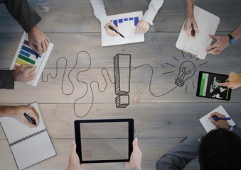 Canvas Print - Overhead of business team with grey wood panel and idea doodle