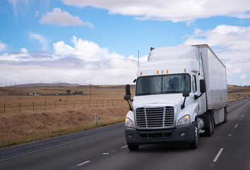 Semi truck big rig on road with meadow background