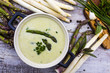 Delicious creamy asparagus soup on a wooden background. 