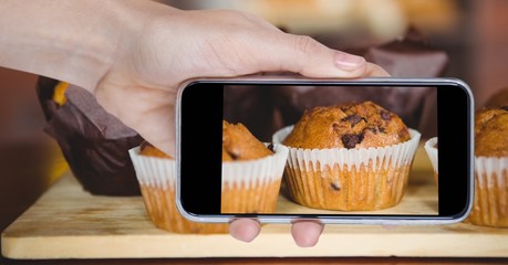 Wall Mural - Hand photographing muffins through smart phone