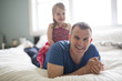 © Louis-Paul Photo - happy father playing with baby on bed