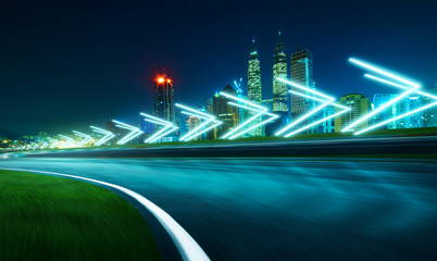 Wall Mural - Motion blurred racetrack with city skyline background ,night scene cold mood. with arrow light Effects.