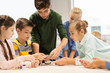 © Syda Productions - happy children building robots at robotics school