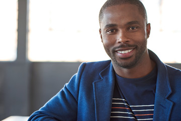 Young African businessman smiling confidently in a modern office