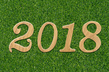 Happy New Year 2018 Of Real Wooden Yellow Brown Letters For Nature Concept Number Idea Over Green Yard Pattern Background