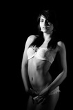 Fototapeta  - black and white or monochrome image of young beautiful slim woman posing nude in white underwear and touching her pussy