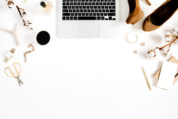 Flat lay fashion blogger gold style desk with laptop and woman accessory collection and cotton branch on white background. Top view.