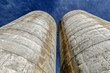 Skyward view of two silos situated close together.
