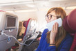 © astrosystem - Girl using cellphone in the airplane.
