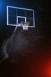 Basketball hoop isolated on black. Basketball arena under rain. Lightened by mixed color lights.