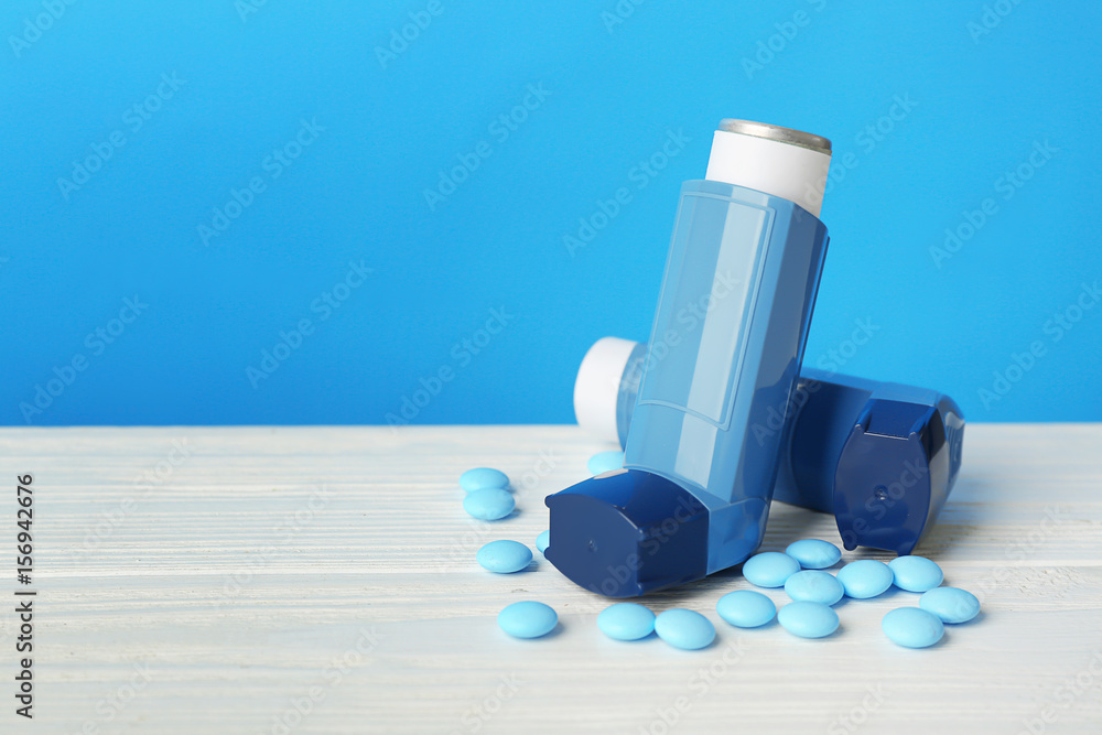 Asthma inhalers with medicine on blue background