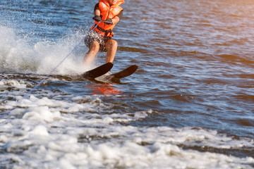 Woman riding water skis closeup. Body parts without a face. Athlete water skiing and having fun. Living a healthy lifestyle and staying active. Water sports theme. Summer by the sea