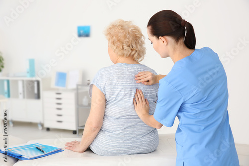 Cuadros en Lienzo Female orthopedist examining senior woman in clinic