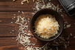 Bowl with delicious grated cheese on wooden background