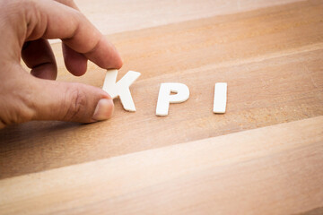 Wall Mural - KPI word with male hand on wood table.Business marketing,analysis concepts