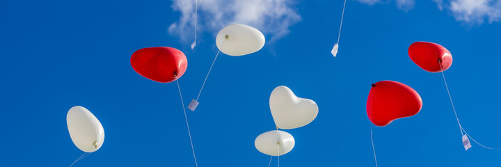 Wall Mural - Heart balloons flying into the sky at a wedding