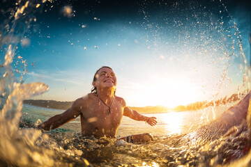 Happy surfer sits on board in the ocean