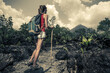 Woman hiker stands on the trail and watching the volcano on the horizon