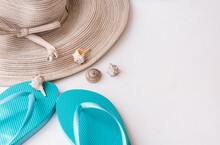 Elegant Women's Straw Hat, Blue Flip Flops, Sea Shells On White Concrete Background, Summer Vacation, Fashion, Clean Minimalist Styled Image