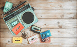 Top view hero header - retro technology of radio cassette recorder music with retro tape cassette on wood table. Vintage color effect styles.