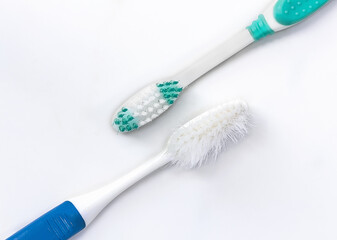 closeup of new and old toothbrush on white background.