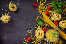 Ingredients For The Preparation Of Italian Pasta - Spaghetti, Fusilli, Fettuccine, Basil, Cherry Tomato And Pepper. Top View With Space For Text.