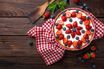 Wall Mural - Delicious strawberry pie with fresh blueberry and whipped cream on wooden rustic table, cheesecake, top view