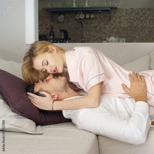 Young Caucasian Couple Lying At Sofa In Living Room At Home