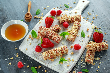 Wall Mural - Granola bar with strawberries, raspberry honey and white chocolate on cutting board