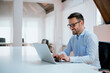 © bnenin - Portrait of young man sitting at his desk in the office