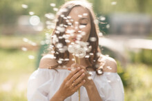 Beautiful Blurry Girl Blowing At The Dandelion At Camera. Simmer Time Pretty Woman Outdoors With Blowball