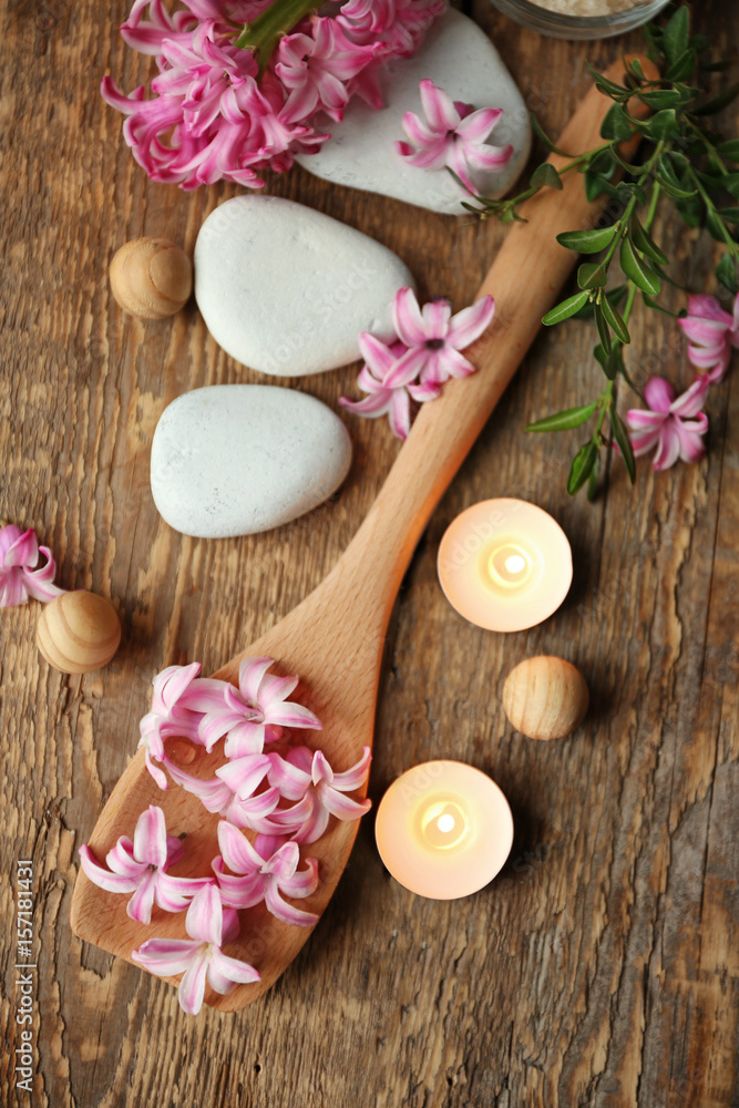 Beautiful spa composition with flowers and candles on wooden background