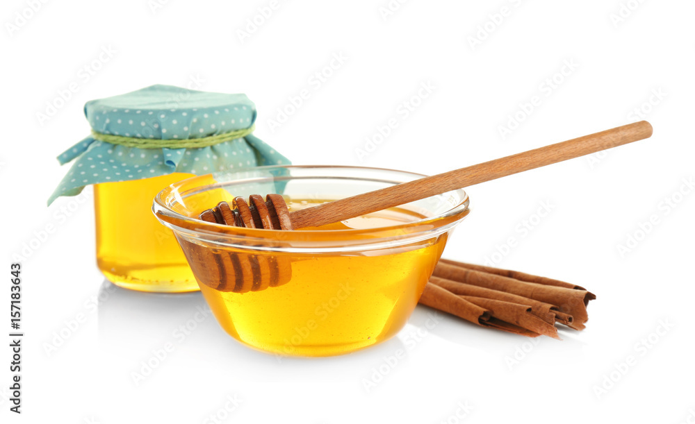 Cinnamon sticks and honey in bowl and jar isolated on white