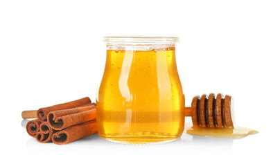 Wall Mural - Cinnamon sticks and honey in jar isolated on white