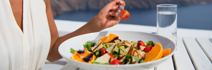 Healthy woman eating salad banner crop of diet meal at restaurant table. Closeup of plate on outdoor cafe terrace plate, luxury dining.